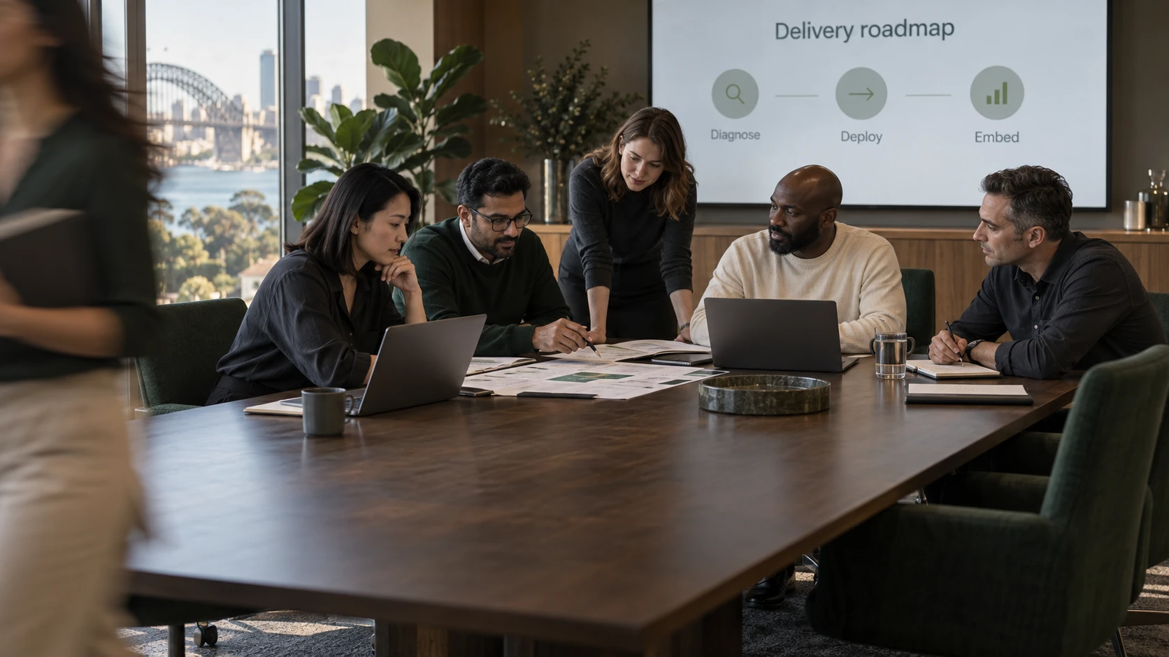 A diverse team collaborating in a boardroom with a projected delivery roadmap.